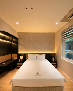 a bedroom with a large white bed in a room at D'la Lento Hotel in Hanoi