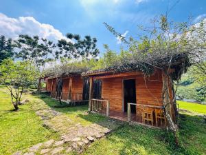 a small wooden house with a porch in a field at B & M Homes in Tả Van