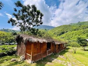 a cabin in a field with a grass roof at B & M Homes in Tả Van