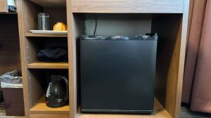 a small black refrigerator in a wooden cabinet at Hotel Excel Okayama in Okayama +50 photos