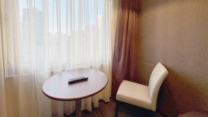 a table and a chair next to a window at Hotel Excel Okayama in Okayama