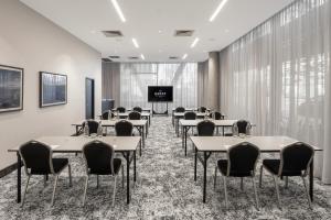 ein Konferenzraum mit Tischen und Stühlen sowie einer Projektionsfläche in der Unterkunft Quest Penrith in Penrith