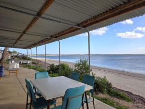 a table and chairs on a beach with the ocean at Jack's Shack in Pine Point