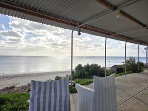 two chairs sitting on a porch looking at the beach at Jack's Shack in Pine Point +11 photos