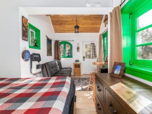 a bedroom with a bed and a living room with green accents at Live Simply Cabin, Walking distance to East Zion trails in Orderville
