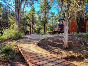 a wooden path leading to a cabin in the woods at Live Simply Cabin, Walking distance to East Zion trails in Orderville +26 photos