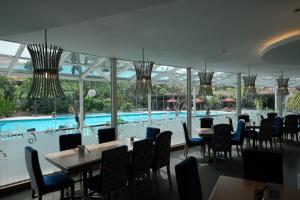 a restaurant with a pool and tables and chairs at The Sunan Hotel Solo in Solo