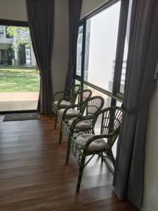 a row of chairs sitting in front of a window at MF Roxy Beach Townhouse Sematan Private Unit L31 in Sematan