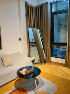 a room with a bed and a table with flowers on it at Bee's House in Hanoi