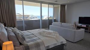 a bedroom with a bed and a couch and a television at Beach & Bubbles in Port Moonta