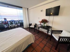 a hotel room with a bed and a table with flowers at Club Colonial Hotel in Huanchaco