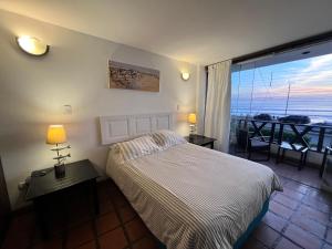 a bedroom with a bed and a view of the ocean at Club Colonial Hotel in Huanchaco