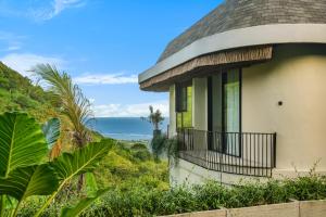 a house with a balcony overlooking the ocean at Makai Lombok in Selong Belanak