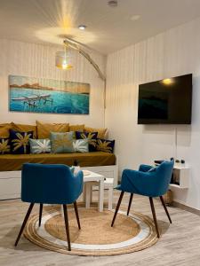 a living room with a couch and two blue chairs at Centre Ville Fare Vairahi in Uturoa