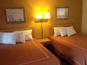 a hotel room with two beds and two lamps at Caravan Motel in Niagara Falls +26 photos