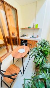 a table and chairs in a room with plants at Jalak Merah in Canggu