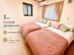 two beds in a room with two single beds at 関口ロイヤルハウス in Tokyo +18 photos