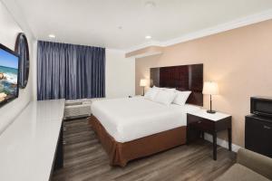a hotel room with a bed and a television at Vista Inn in Vista +6 photos