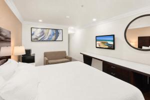 a hotel room with a bed and a mirror at Vista Inn in Vista