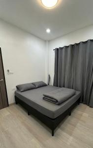 a bed sitting in a room with a curtain at The Summer Cozy Cottage 2 in Haad Chao Phao