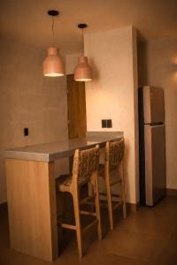a kitchen with a counter with chairs and a refrigerator at Ciruelo Tuyo in La Paz