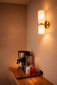 a coffee maker on a wooden shelf under a lamp at Ciruelo Tuyo in La Paz +17 photos