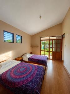 two beds in a room with two windows at Refugio Amazónico in San Martín