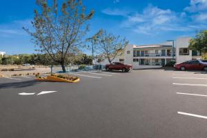 a parking lot with a red truck in front of a building at Vista Inn in Vista