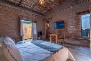 a bedroom with a bed in a brick wall at La Piamonte 1903 in Azcuénaga