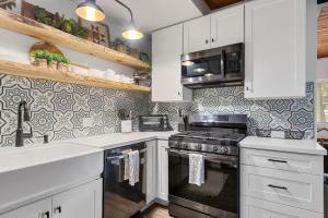a kitchen with white cabinets and a stove top oven at Brunos Bungalow in Big Bear Lake