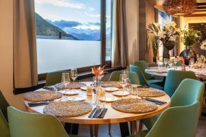 a dining room with tables and chairs and a large window at Meliá de Tredós in Tredós