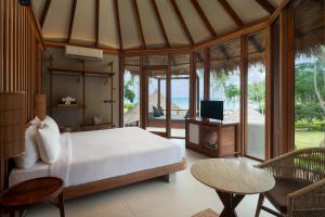 a bedroom with a bed and a desk and a television at Haadtien Beach Resort in Ko Tao