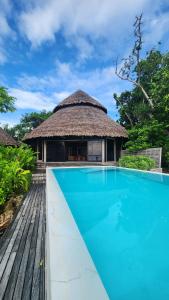 a villa with a swimming pool and a hut at Black Pearl Resort in Espiritu Santo