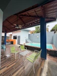 a patio with chairs and a swimming pool at Casa Pacífico Esterillos in Esterillos