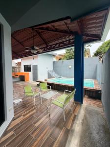 a patio with chairs and a table and a pool at Casa Pacífico Esterillos in Esterillos
