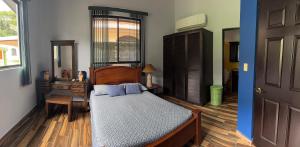 a bedroom with a bed and a dresser and a door at Casa Pacífico Esterillos in Esterillos