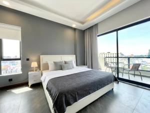 a bedroom with a large bed and a balcony at Sky Hotel - Cinema rooms & Apartments - Free laundry in Sihanoukville