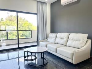 a living room with a white couch and a table at Sky Hotel - Cinema rooms & Apartments - Free laundry in Sihanoukville +86 photos