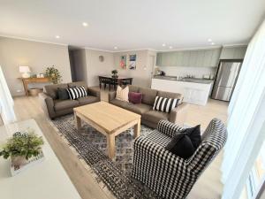 a living room with a couch and a table at Ramsay House in Port Vincent