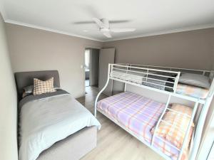 a bedroom with a bunk bed and a ceiling fan at Ramsay House in Port Vincent