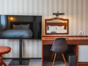a bedroom with a bed and a desk with a mirror at TsukubaNoYu Urban Hotel in Tsukuba +59 photos