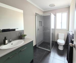 a bathroom with a shower and a sink and a toilet at Ramsay House in Port Vincent +10 photos