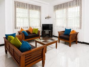 a living room with two couches and a tv at Ivy Garden Retreat in Gampola