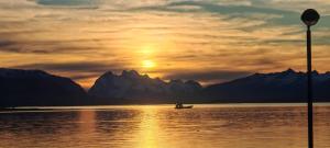 a person in a boat on the water at sunset at Julieta House in Puerto Natales