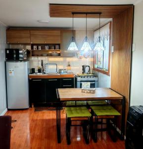 a kitchen with a wooden table and a refrigerator at Julieta House in Puerto Natales