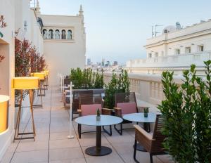 a row of tables and chairs on a rooftop patio at INNSiDE by Meliá Madrid Gran Vía in Madrid +88 photos