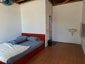 a bedroom with a bed and a sink in it at Batu Mela Cottage in Banggai