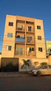 a building with a car parked in front of it at Doce Lar 3 in Pouso Alegre