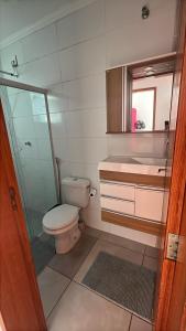 a bathroom with a toilet and a shower and a sink at Doce Lar 3 in Pouso Alegre +22 photos