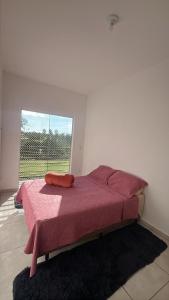 a bedroom with a bed with a red blanket on it at Doce Lar 3 in Pouso Alegre